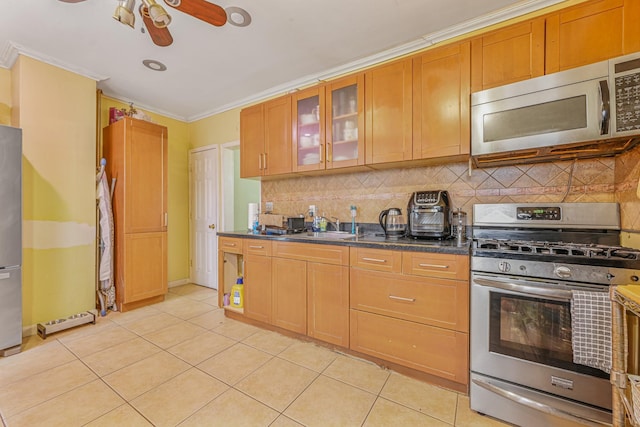 kitchen featuring ceiling fan, tasteful backsplash, crown molding, stainless steel appliances, and light tile patterned floors