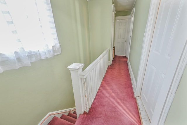 hall with light colored carpet