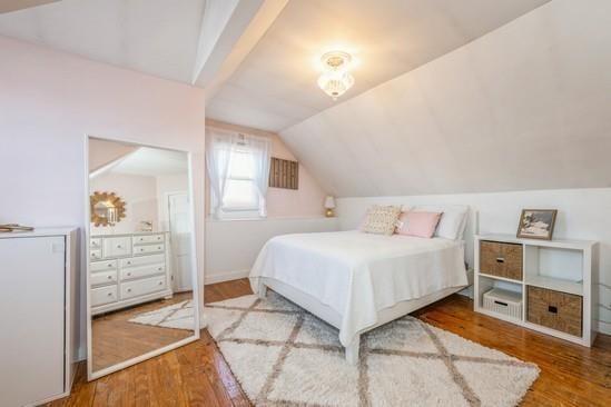 bedroom featuring hardwood / wood-style floors and vaulted ceiling