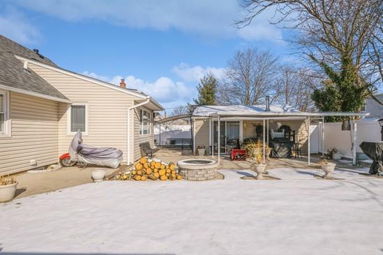 rear view of property with a fire pit and a patio area