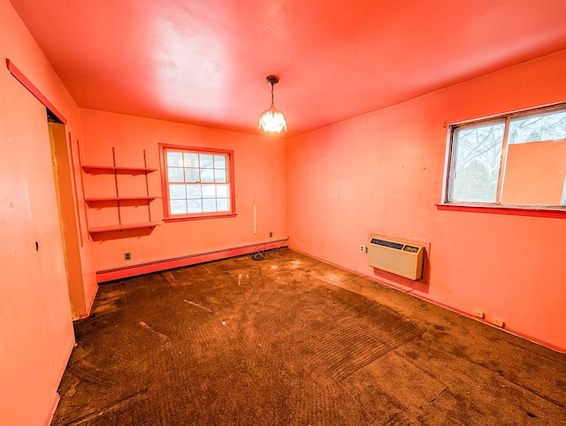 carpeted spare room with baseboard heating and a wall unit AC