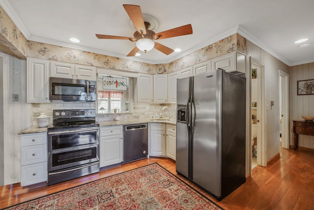 kitchen featuring sink, white cabinetry, appliances with stainless steel finishes, and ornamental molding