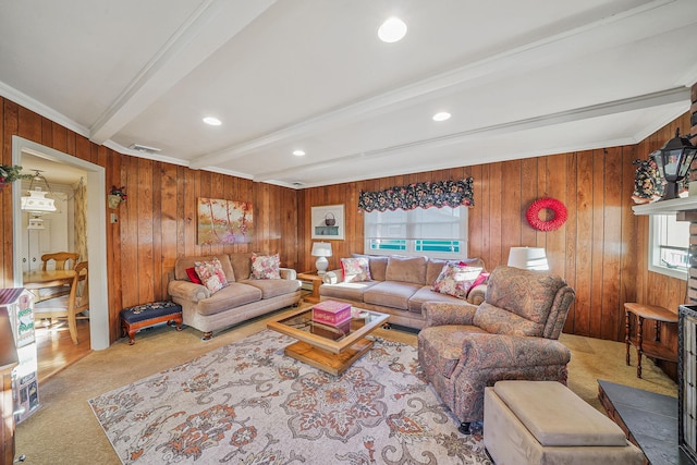 carpeted living room featuring beam ceiling, wooden walls, and ornamental molding