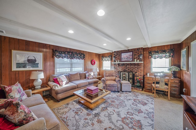 living room with a brick fireplace, ornamental molding, wood walls, and beamed ceiling