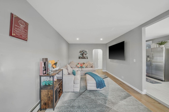 living room featuring a baseboard heating unit and hardwood / wood-style floors