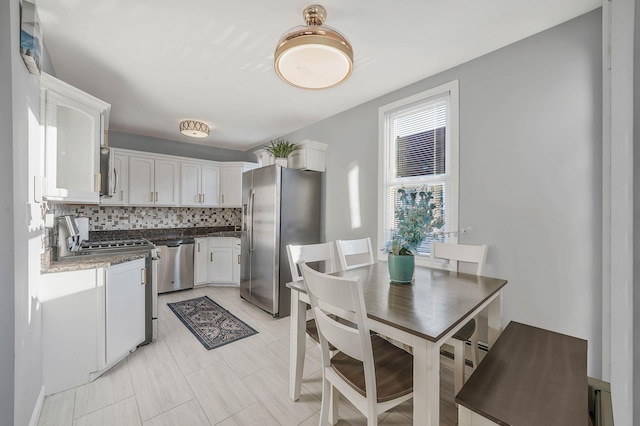 kitchen featuring tasteful backsplash, stainless steel appliances, and white cabinetry