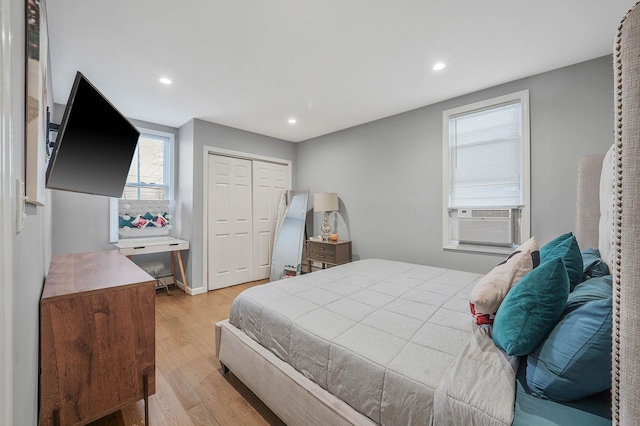 bedroom with a closet, cooling unit, and light hardwood / wood-style flooring