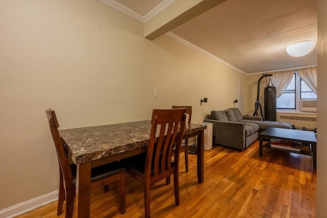 dining room with radiator heating unit, ornamental molding, and hardwood / wood-style flooring