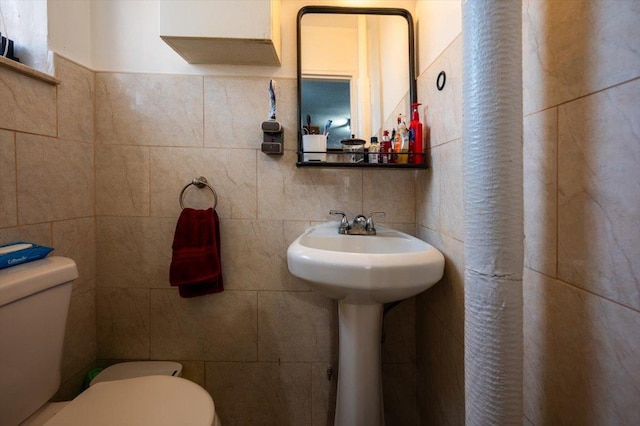 bathroom with backsplash, toilet, and tile walls