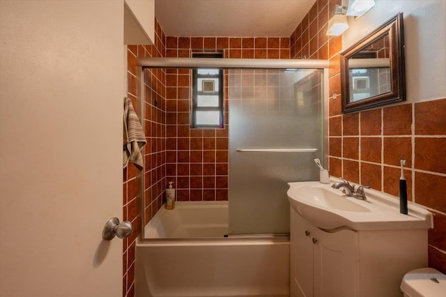 full bathroom featuring toilet, tile walls, enclosed tub / shower combo, and vanity