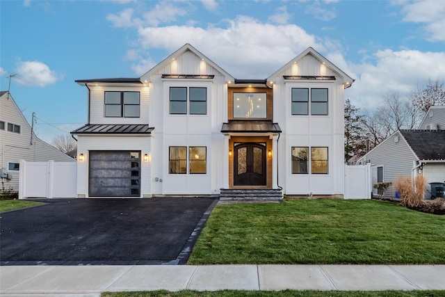 modern inspired farmhouse with a front lawn and a garage