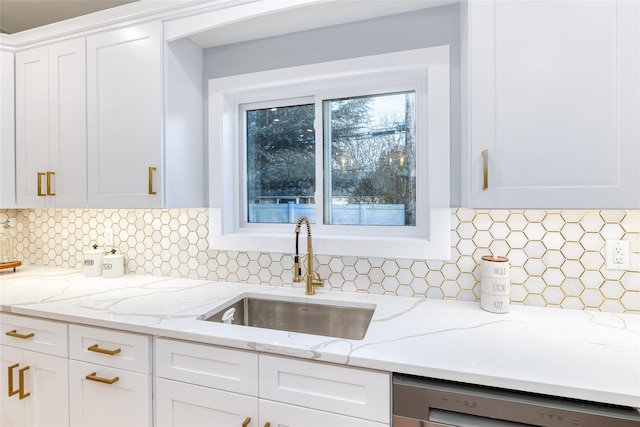 kitchen featuring white cabinetry, decorative backsplash, dishwasher, and sink