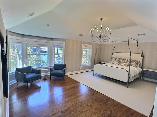 bedroom with hardwood / wood-style flooring, an inviting chandelier, and vaulted ceiling