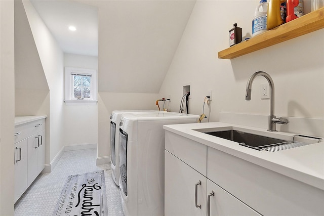 laundry room featuring cabinets, separate washer and dryer, light tile patterned floors, and sink