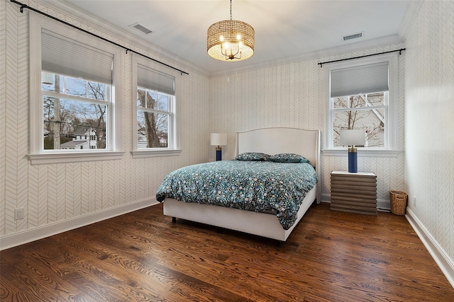 bedroom with dark hardwood / wood-style flooring, crown molding, and a chandelier