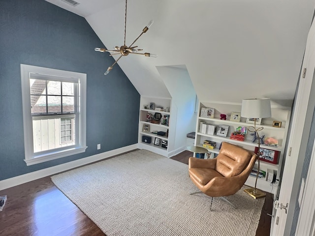 sitting room with dark wood-type flooring, lofted ceiling, and built in features