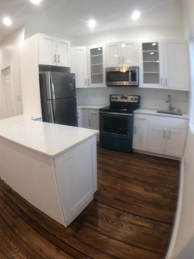 kitchen with dark hardwood / wood-style floors, stainless steel appliances, white cabinets, and sink