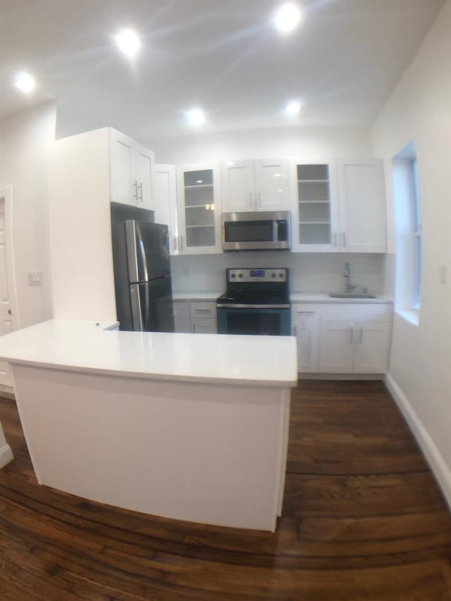 kitchen featuring white cabinetry, stainless steel appliances, sink, dark hardwood / wood-style floors, and kitchen peninsula