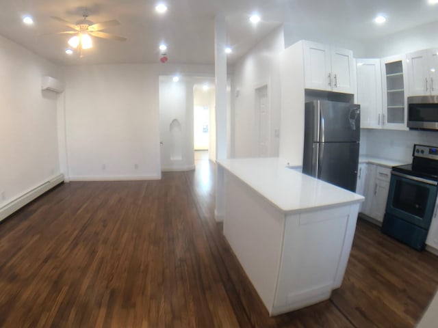 kitchen featuring an AC wall unit, dark hardwood / wood-style floors, stainless steel appliances, and white cabinetry