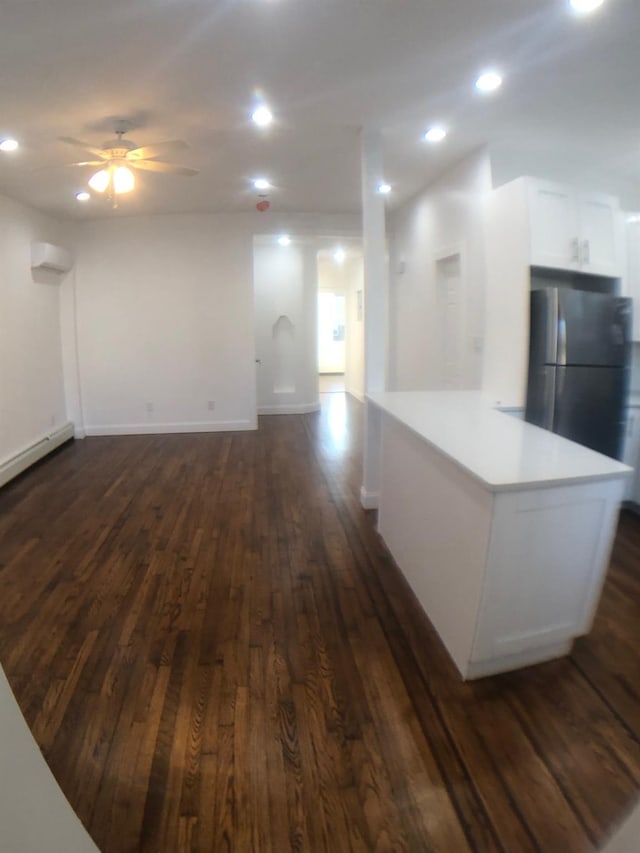 interior space with a wall unit AC, dark wood-type flooring, and ceiling fan