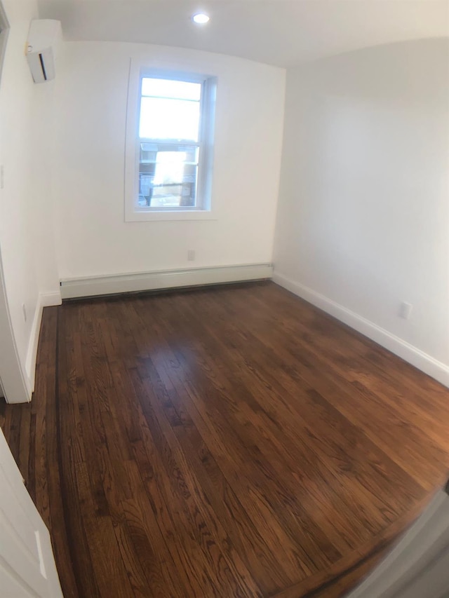 unfurnished room featuring dark hardwood / wood-style floors and a baseboard radiator