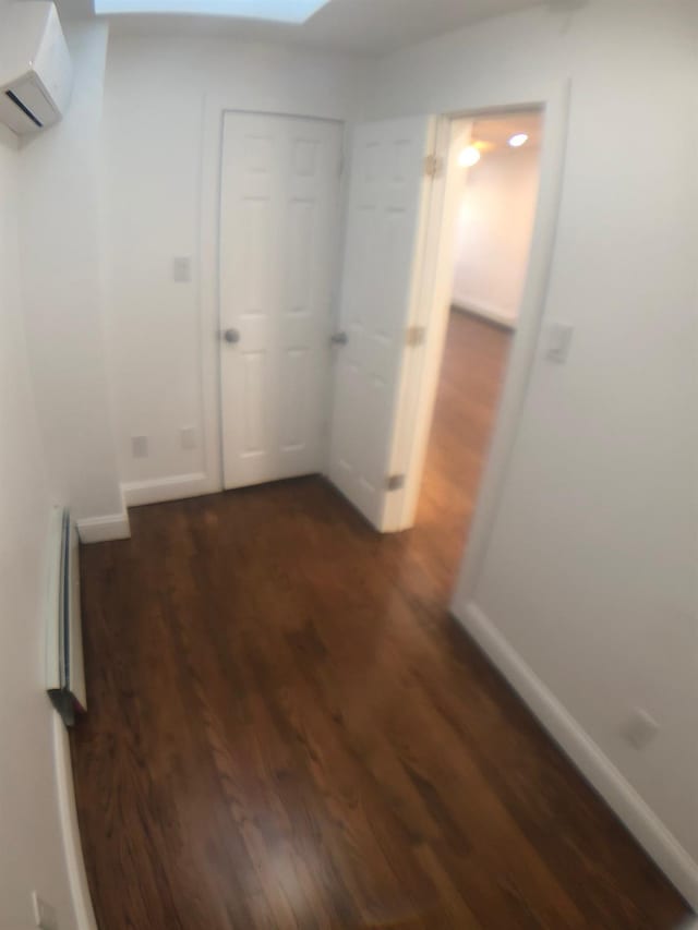 hall with a wall unit AC and dark hardwood / wood-style floors