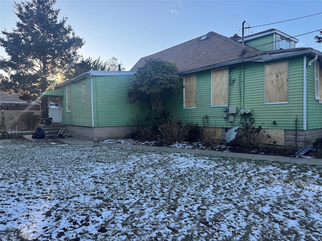 view of snow covered rear of property