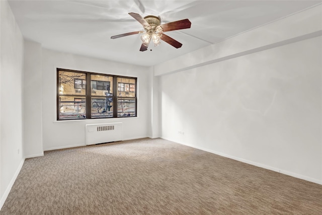 empty room with carpet flooring, radiator, and ceiling fan