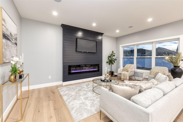 living room featuring light wood-type flooring and a fireplace