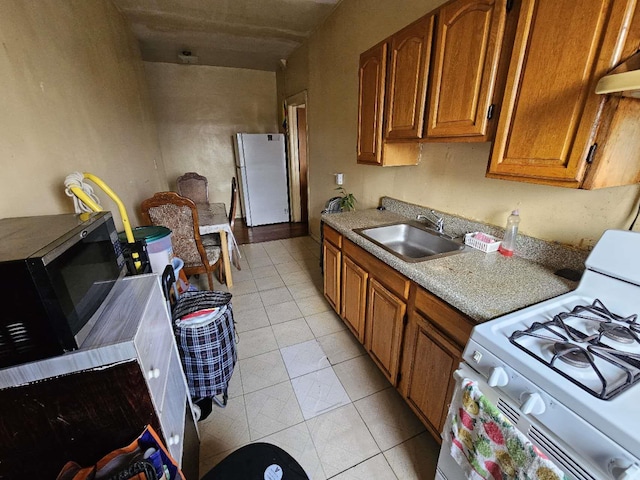 kitchen featuring sink, white appliances, and light tile patterned floors