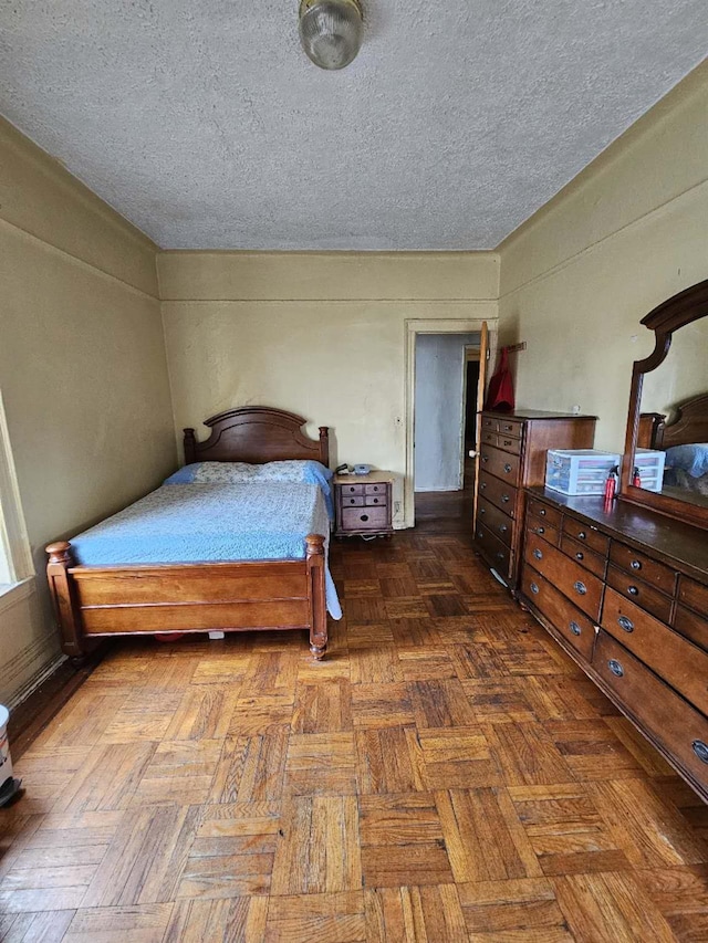 bedroom featuring a textured ceiling and dark parquet flooring