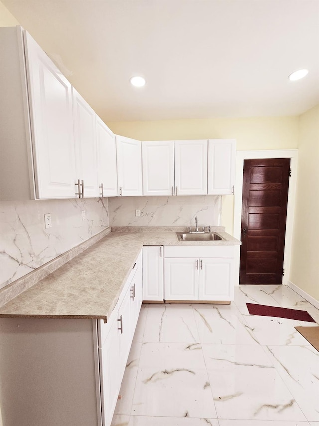 kitchen with white cabinets, backsplash, and sink