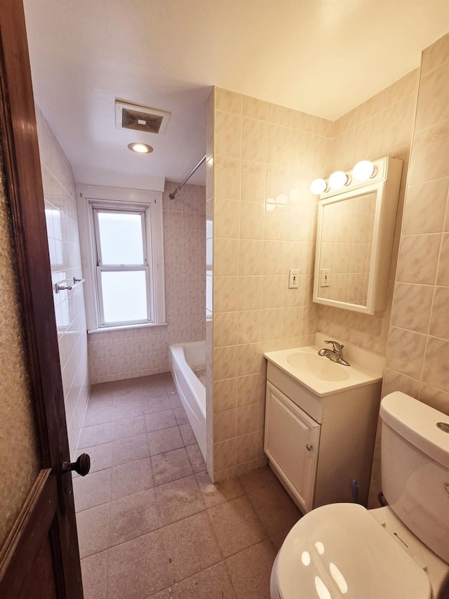 bathroom featuring tile walls, toilet, and vanity