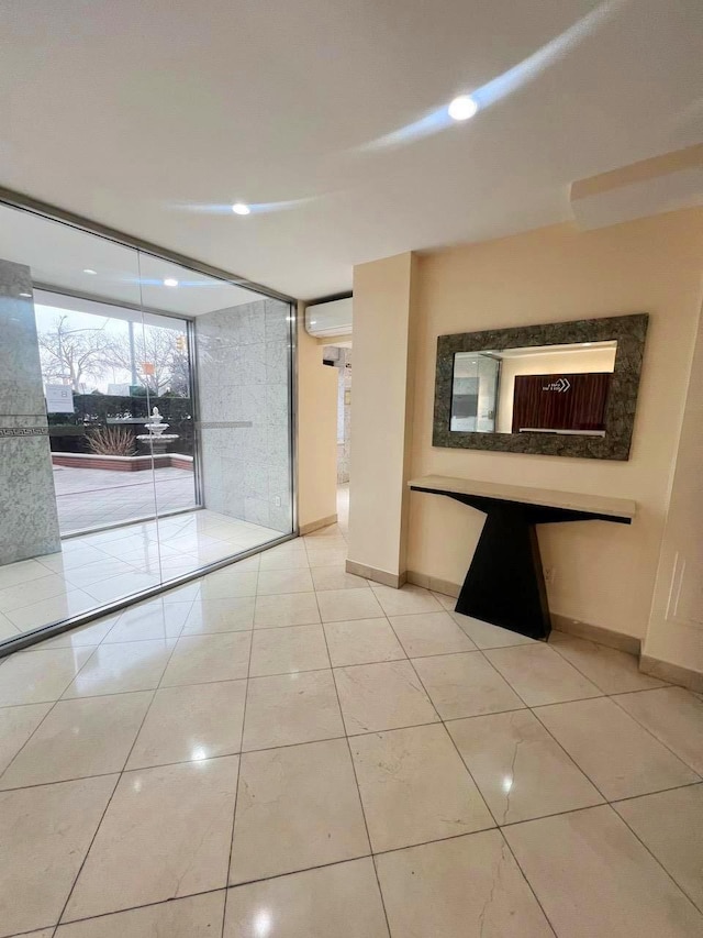 tiled spare room with a wall unit AC