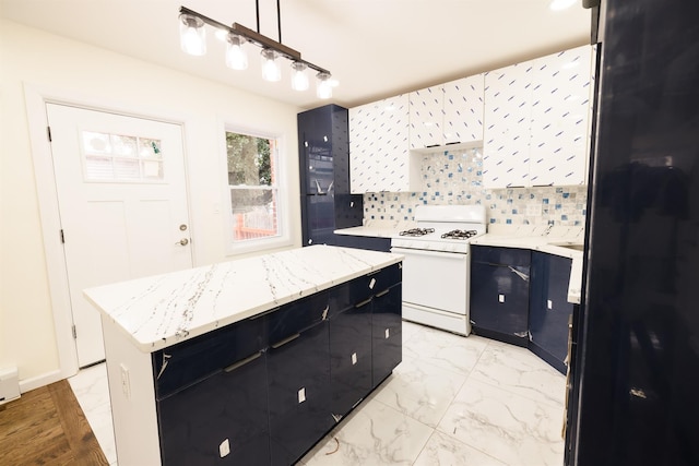 kitchen with decorative light fixtures, tasteful backsplash, a center island, white cabinetry, and white gas range