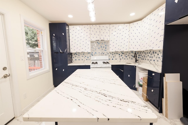 kitchen featuring light stone counters, white gas range, and a kitchen island