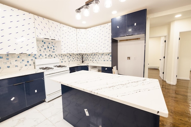 kitchen featuring backsplash, a center island, light stone countertops, white gas range oven, and sink