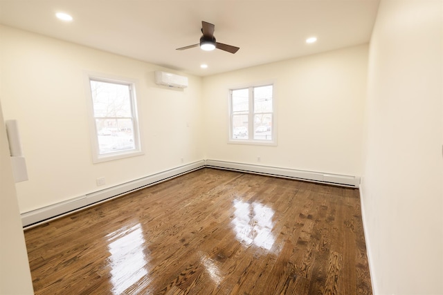 empty room featuring ceiling fan, plenty of natural light, hardwood / wood-style flooring, and a wall mounted air conditioner