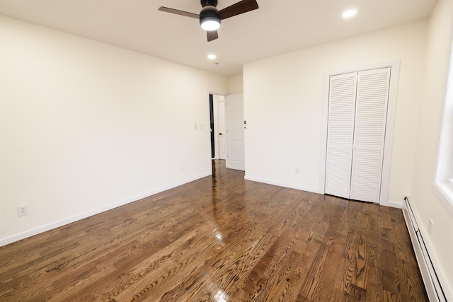 unfurnished bedroom with dark wood-type flooring, ceiling fan, a closet, and a baseboard radiator