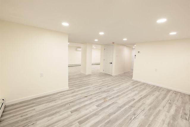 unfurnished room with light wood-type flooring and a baseboard heating unit