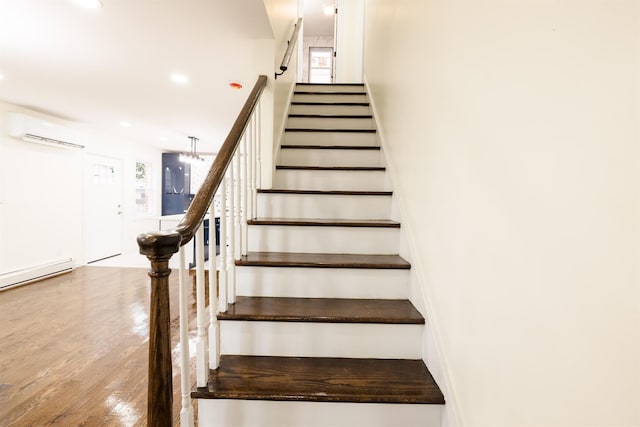 staircase with hardwood / wood-style flooring, a baseboard radiator, a chandelier, and a wall mounted air conditioner