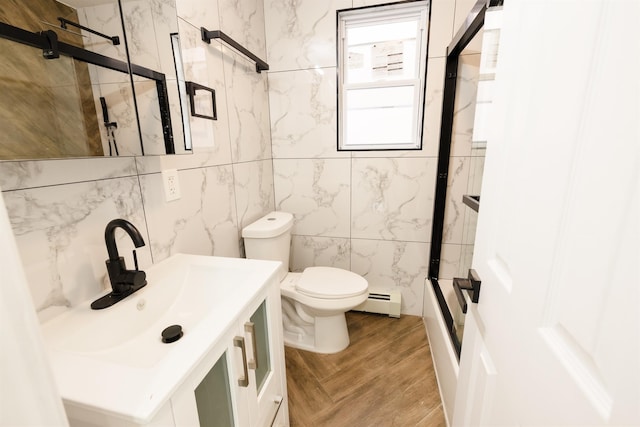 full bathroom featuring toilet, baseboard heating, tile walls, wood-type flooring, and vanity