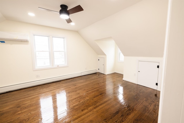 additional living space with baseboard heating, dark hardwood / wood-style flooring, a wall mounted AC, vaulted ceiling, and ceiling fan