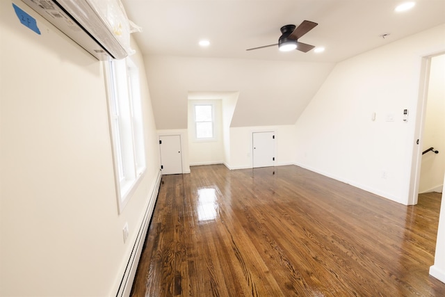 bonus room featuring lofted ceiling, ceiling fan, dark hardwood / wood-style floors, a wall mounted air conditioner, and a baseboard radiator