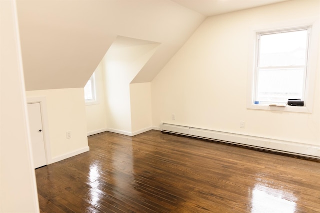 bonus room featuring a baseboard heating unit, dark hardwood / wood-style floors, and vaulted ceiling