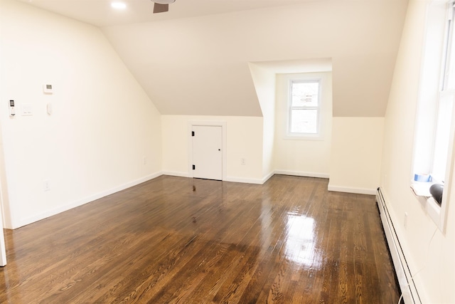 bonus room featuring baseboard heating, lofted ceiling, dark hardwood / wood-style floors, and ceiling fan