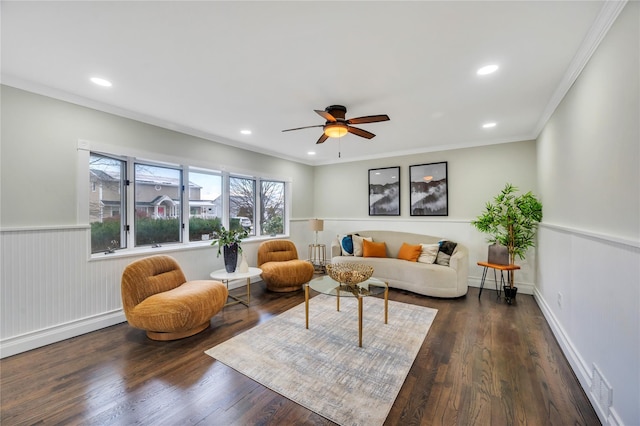 living room with dark wood-type flooring, ornamental molding, and ceiling fan