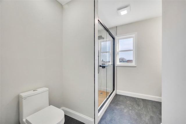 bathroom with a shower with shower door and toilet