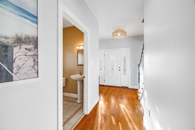 hallway featuring sink and light hardwood / wood-style floors