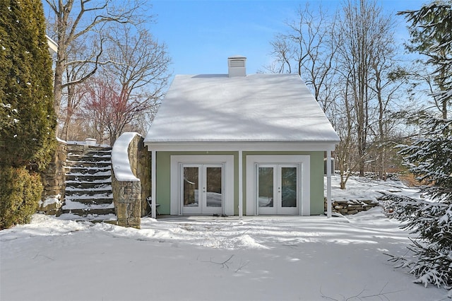 snow covered property with french doors